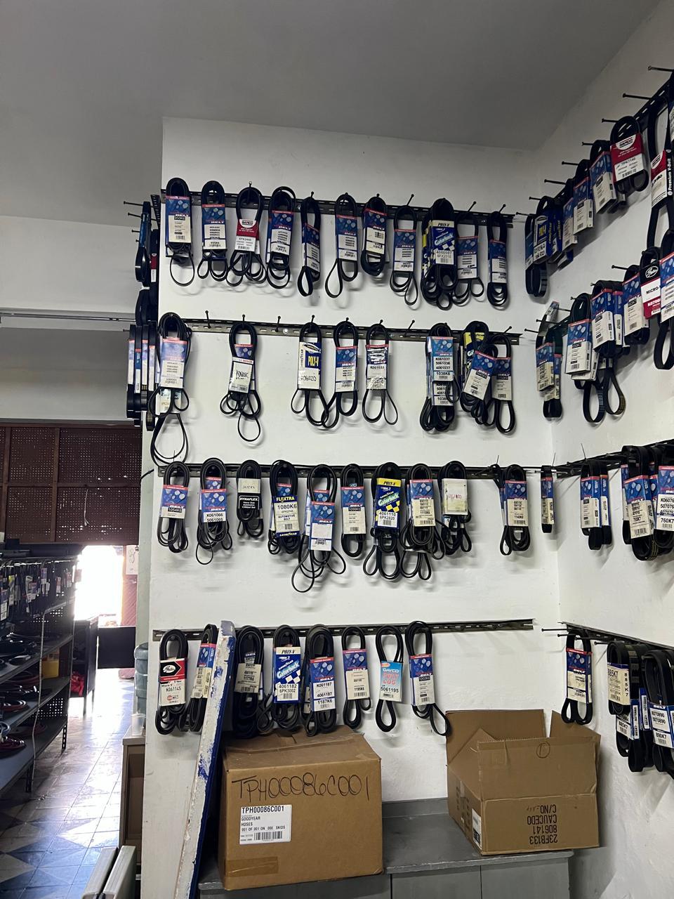 Pared de exhibición con correas automotrices colgadas y etiquetadas